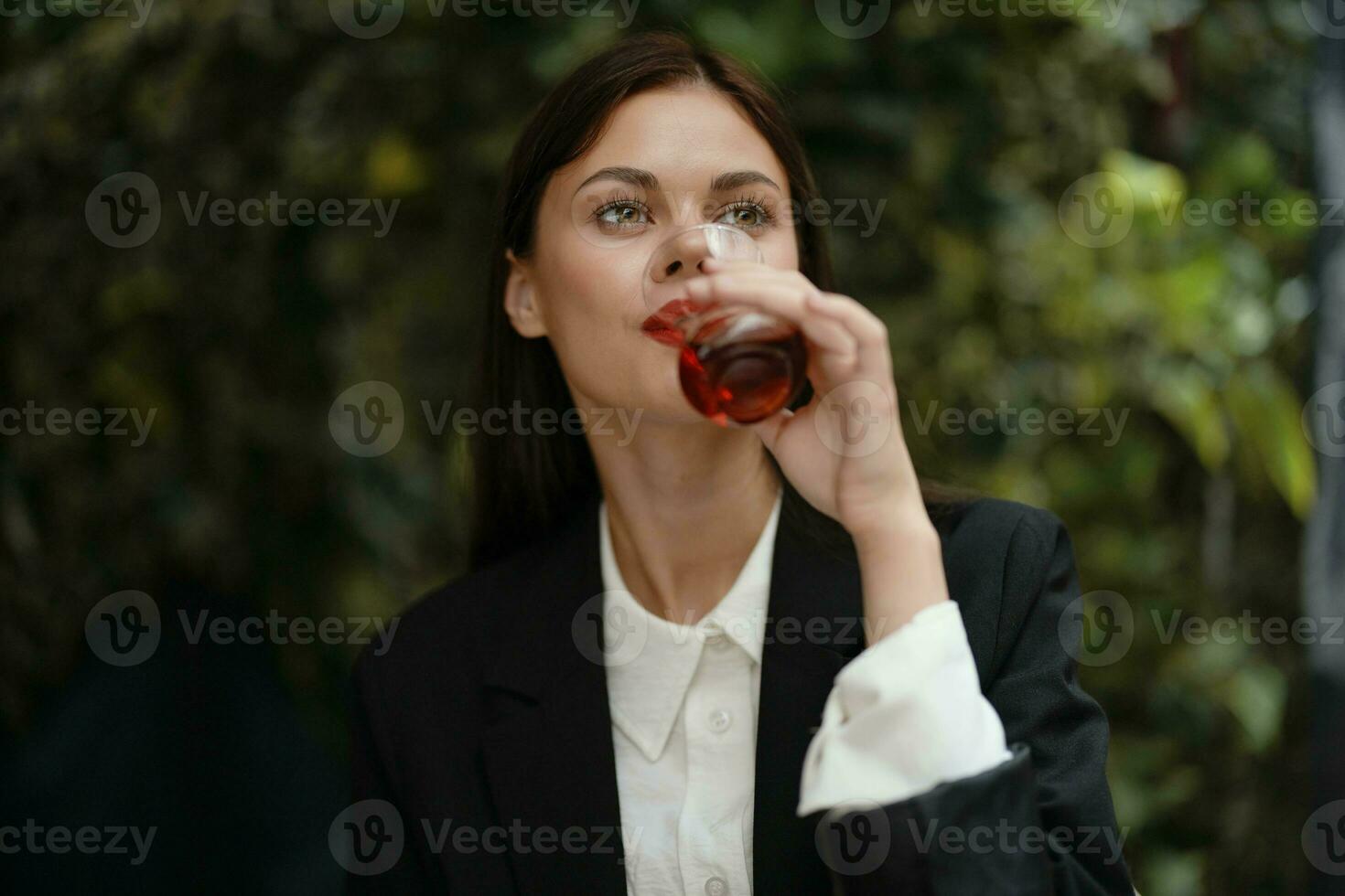 mulher com vermelho lábios sorrir com dentes bebendo chá dentro uma cafeteria a partir de uma turco vidro caneca em a rua, verão viagem, período de férias dentro a cidade foto