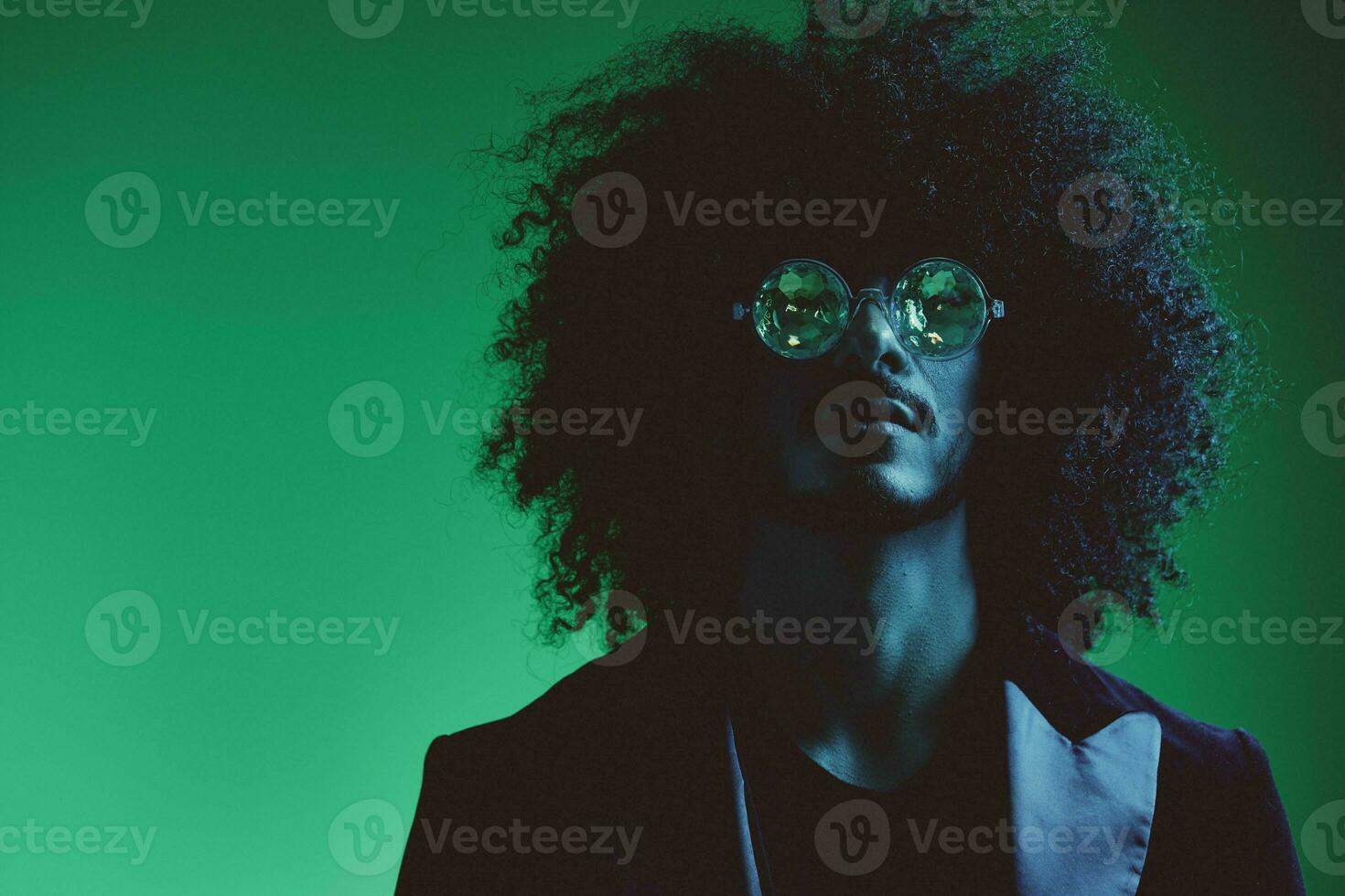 moda retrato do uma homem com encaracolado cabelo em uma verde fundo com oculos de sol, multinacional, colori Rosa luz, na moda, moderno conceito. foto