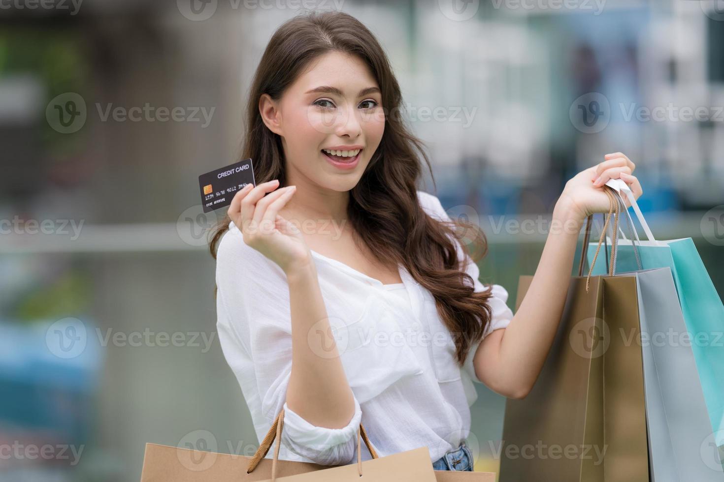 retrato ao ar livre de uma mulher feliz segurando sacolas de compras e um rosto sorridente foto