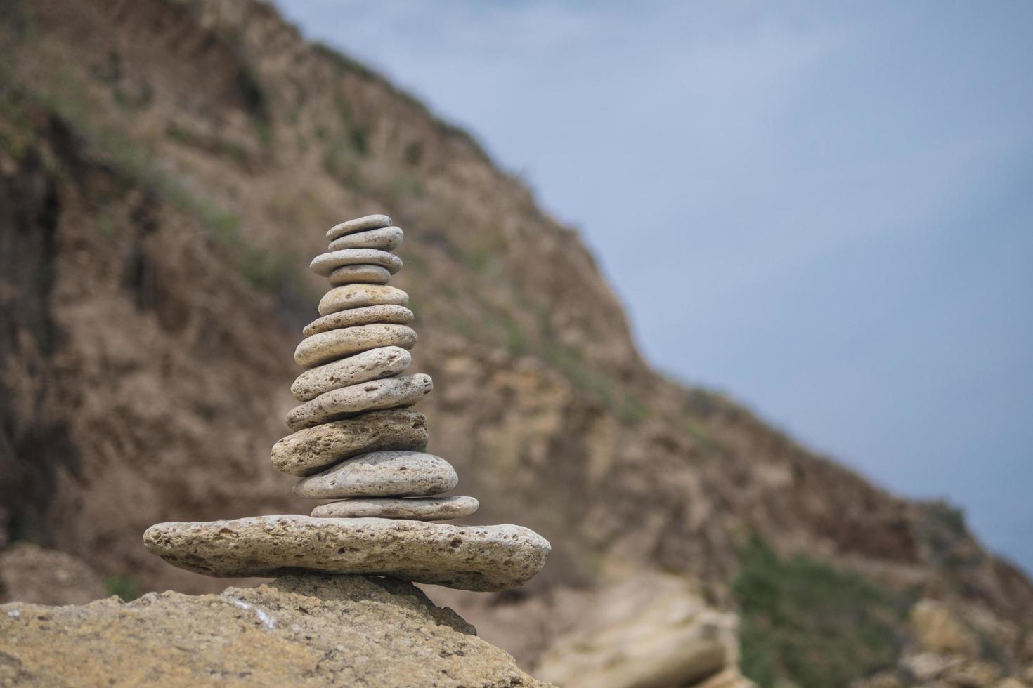 pirâmide de pedras de equilíbrio em uma grande pedra à beira-mar foto