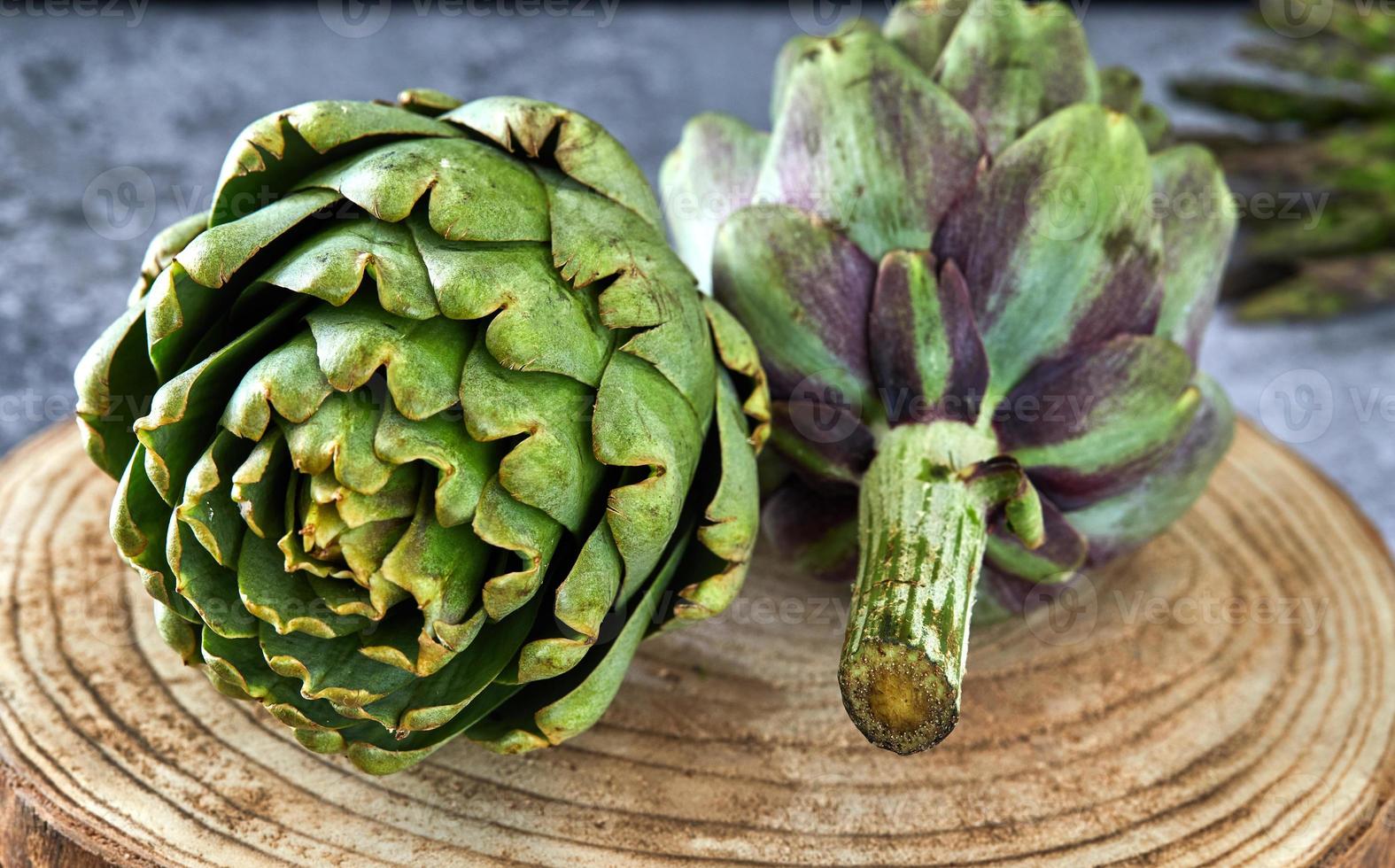 alcachofras com verduras em suporte de madeira foto