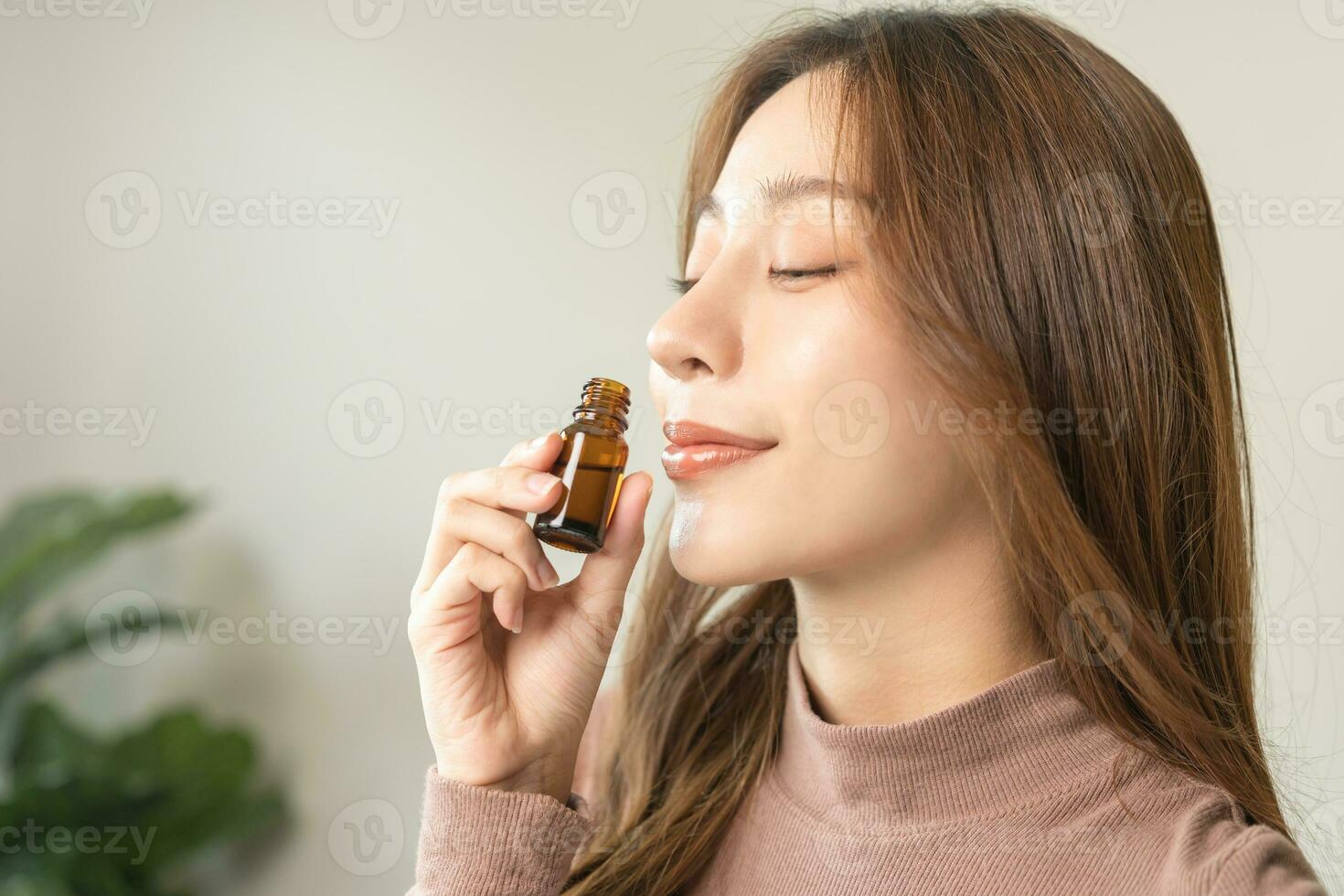 aromaterapia, atraente ásia jovem mulher, menina face expressão desfrutando cheiro fragrância do ervas a partir de remédio natural orgânico essencial perfume óleo às lar. terapia tratamento, beleza pele Cuidado. foto