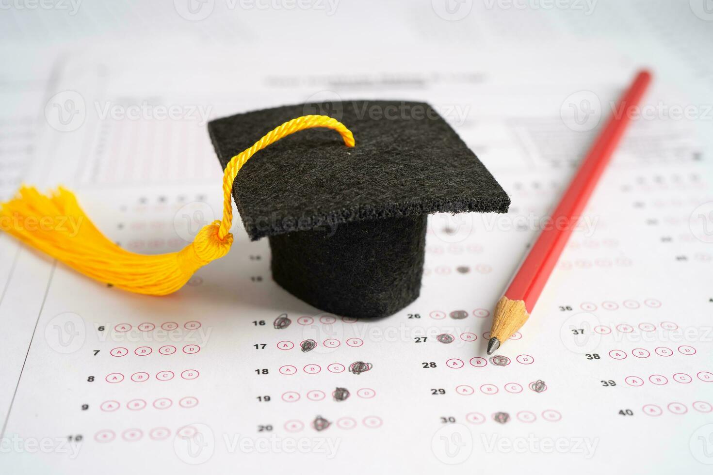 chapéu de lacuna de graduação e lápis no fundo da folha de respostas, estudo de educação, teste de aprendizagem, conceito de ensino. foto