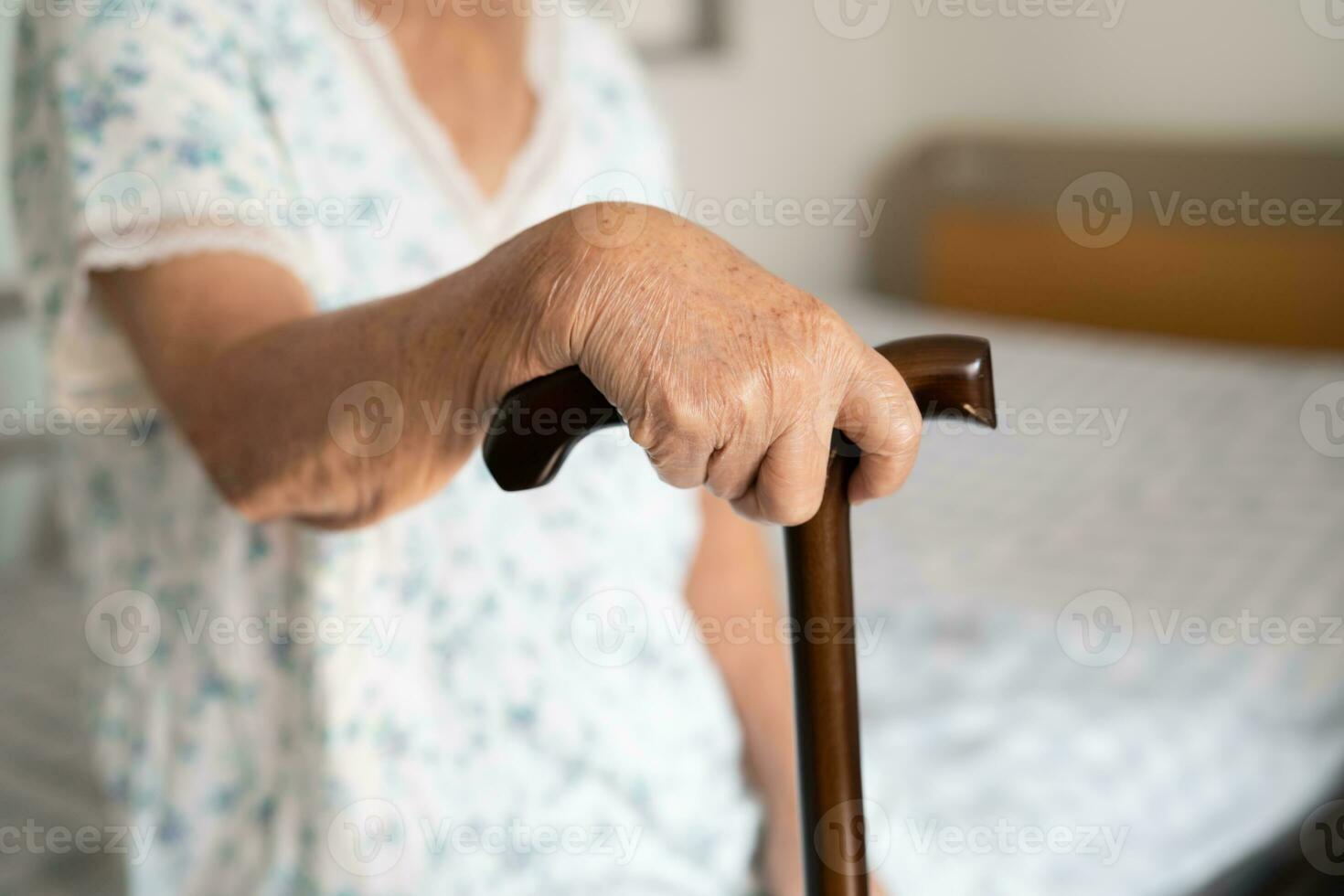 ásia idosos incapacidade mulher segurando caminhando grudar, madeira bengala, volta lidar, caminhando ajuda para Socorro para andar. foto