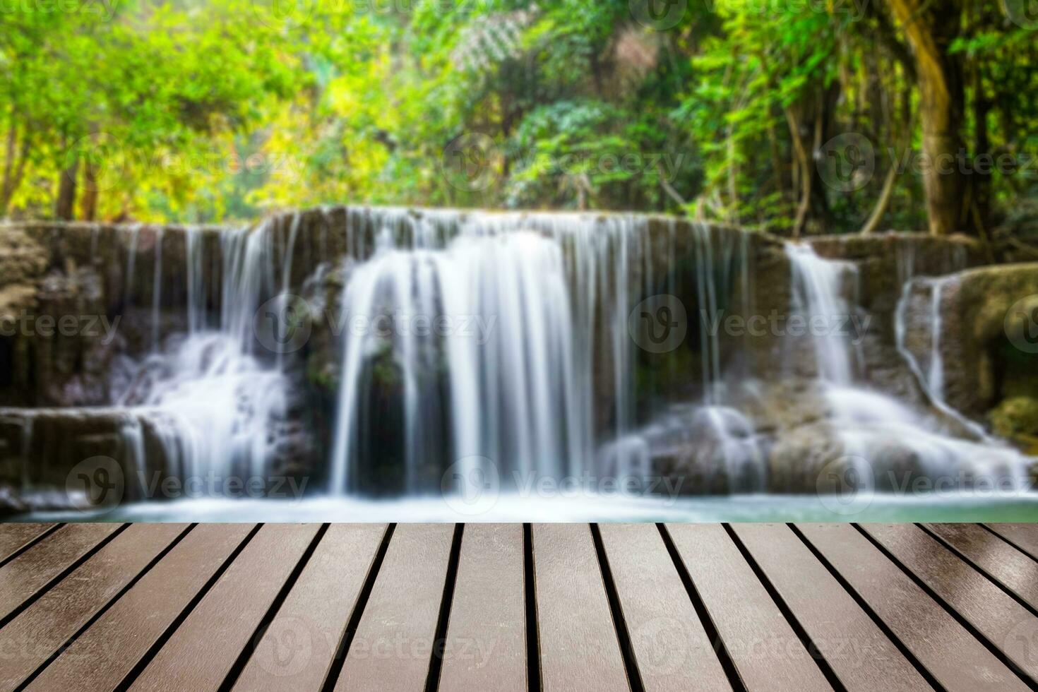 madeira mesa topo em borrado cascata profundo floresta foto