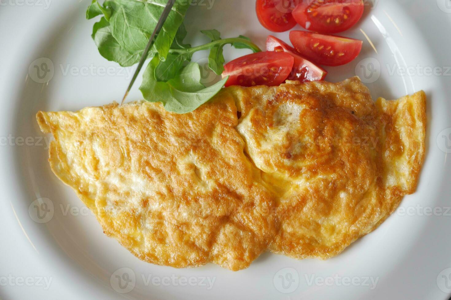 ovo omelete e cereja tomate em uma prato para manhã café da manhã foto