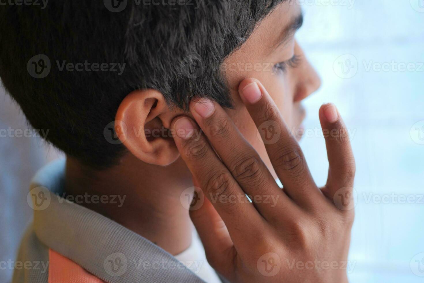 adolescente com dor de ouvido tocando sua orelha dolorosa, foto