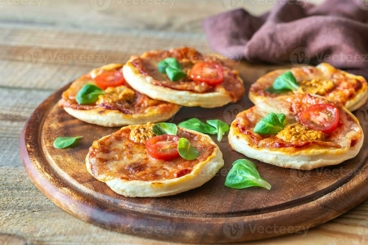 mini pizzas na tábua de madeira foto