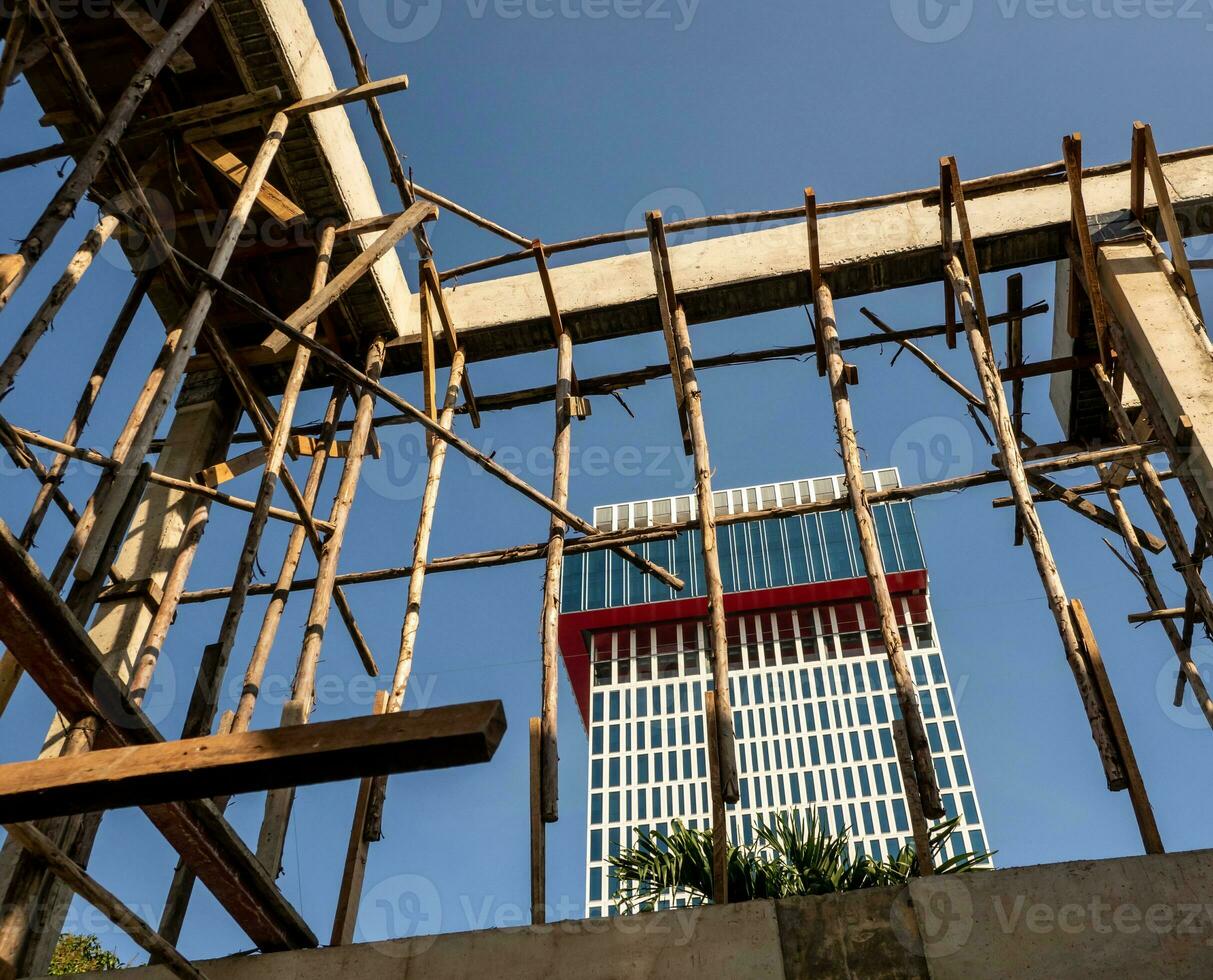 poste de madeira temporário para suportar a estrutura de concreto de um prédio em construção foto