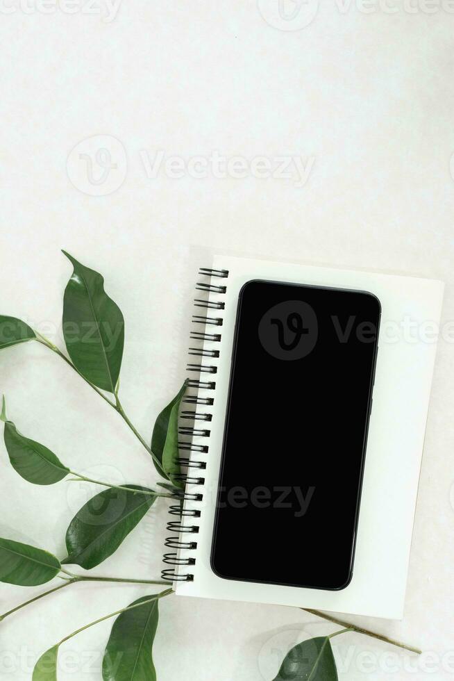 inteligente telefone brincar com espiral caderno em branco fundo. foto