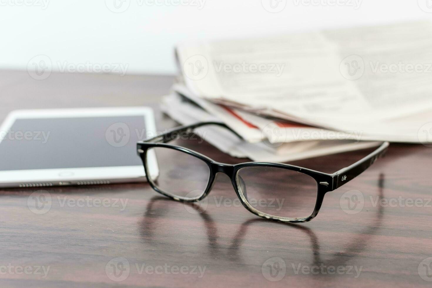 jornal e lendo óculos em de madeira mesa. foto