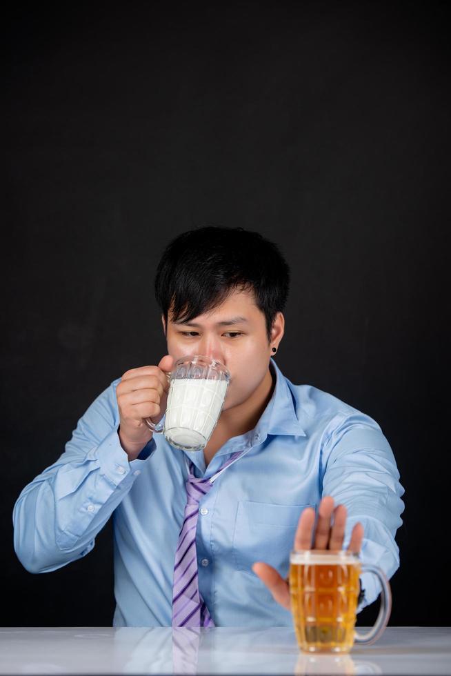 retrato de homem de negócios com cerveja e leite nas mãos em casa isolado foto