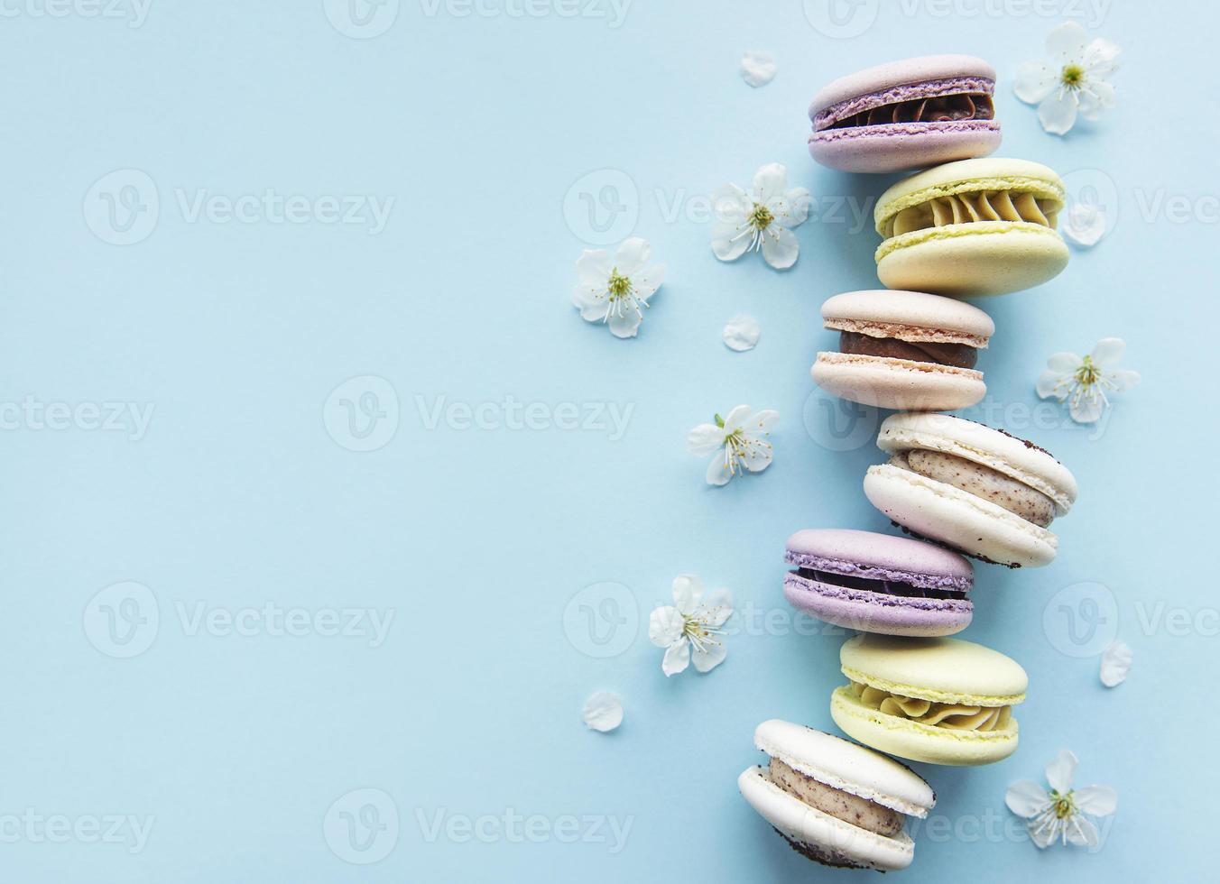 macaroons coloridos dispostos sobre fundo azul foto