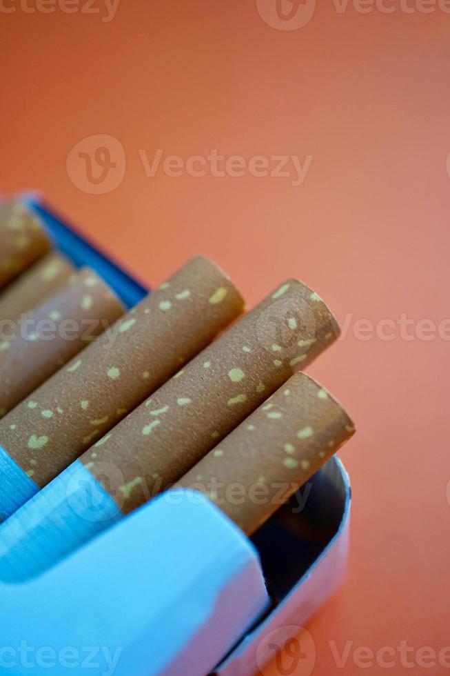 tabaco de cigarro em fundo laranja foto