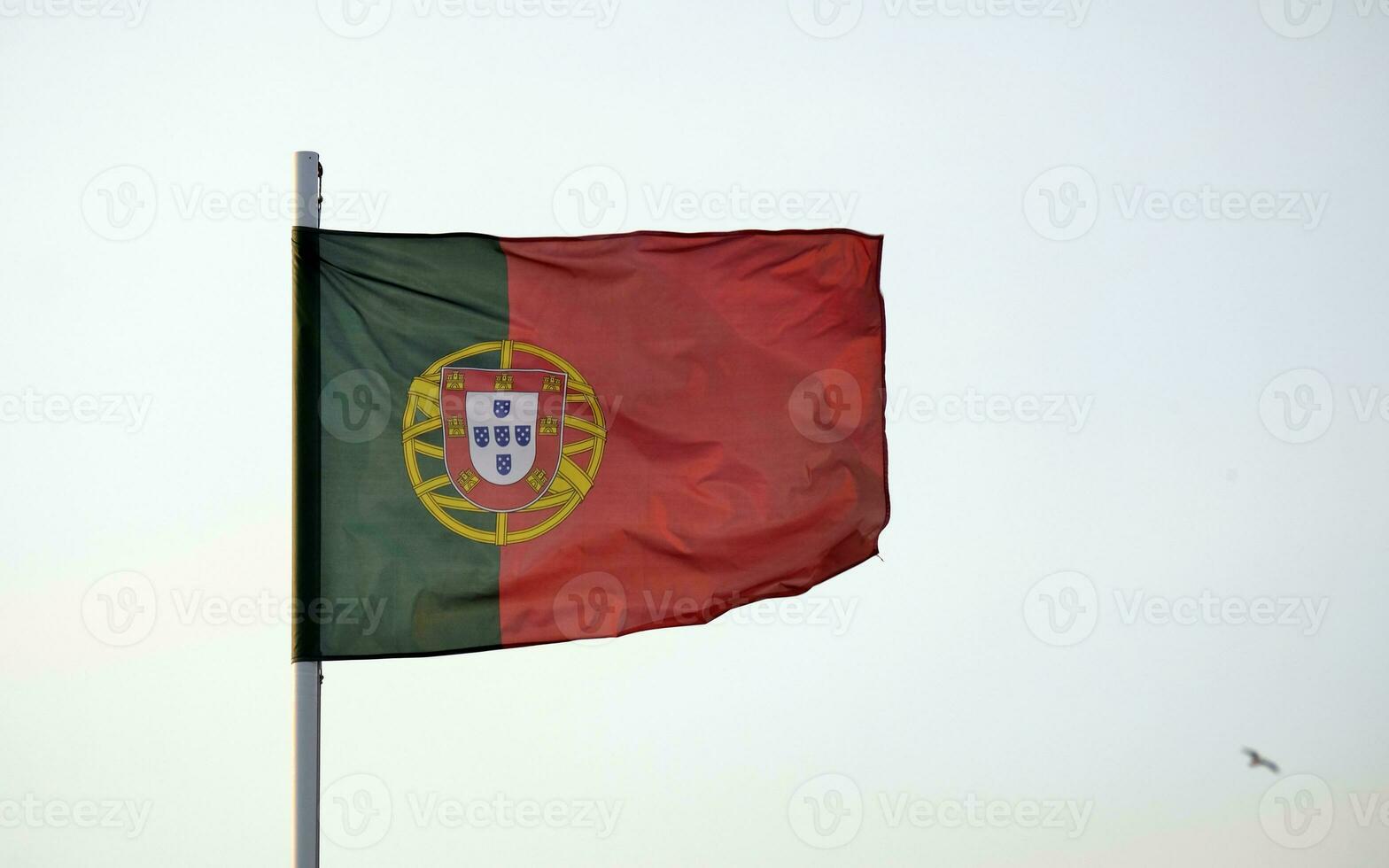 Português bandeira acenando dentro a vento contra uma Claro céu foto