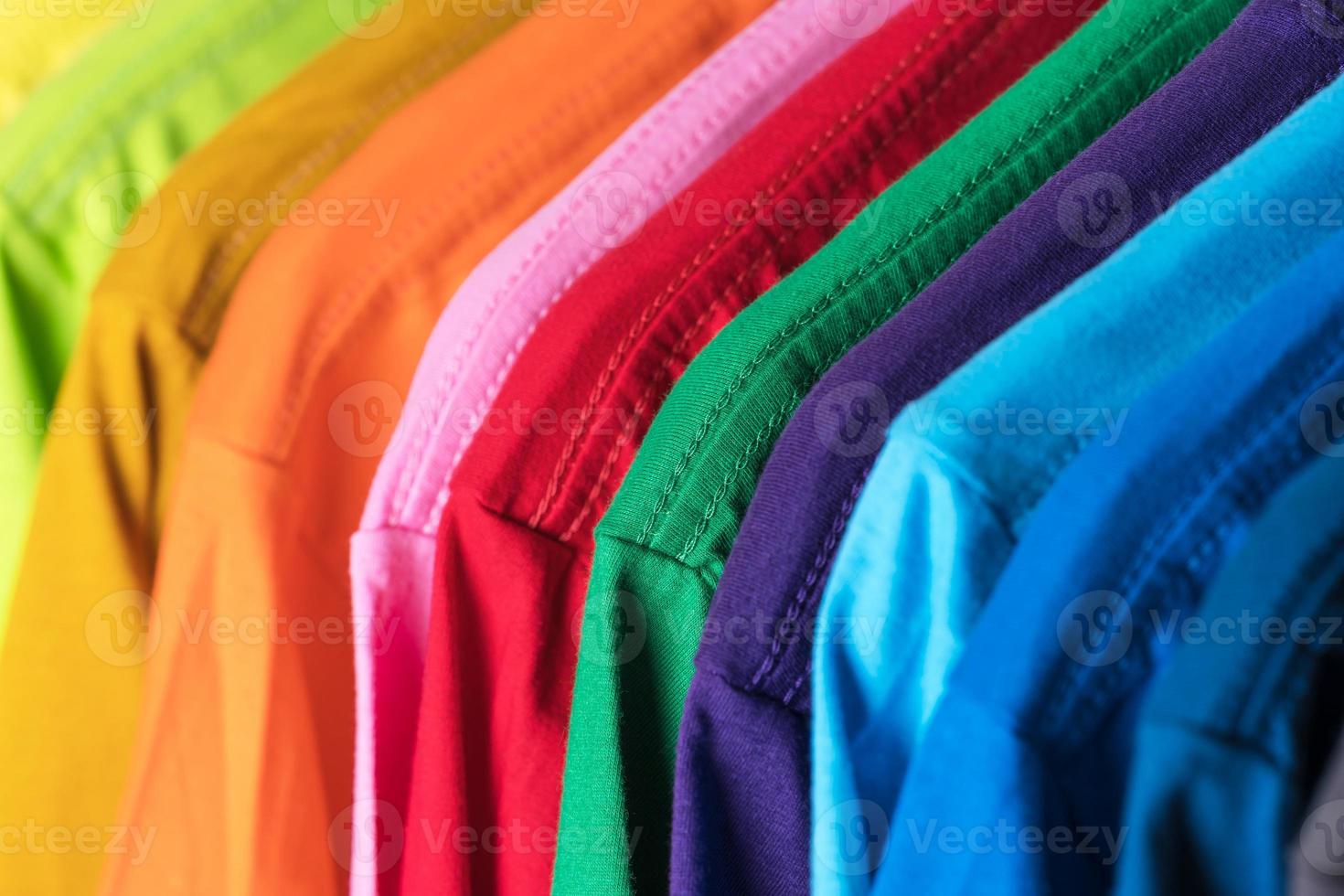 close-up de camisetas de roupas em cabides no fundo branco foto