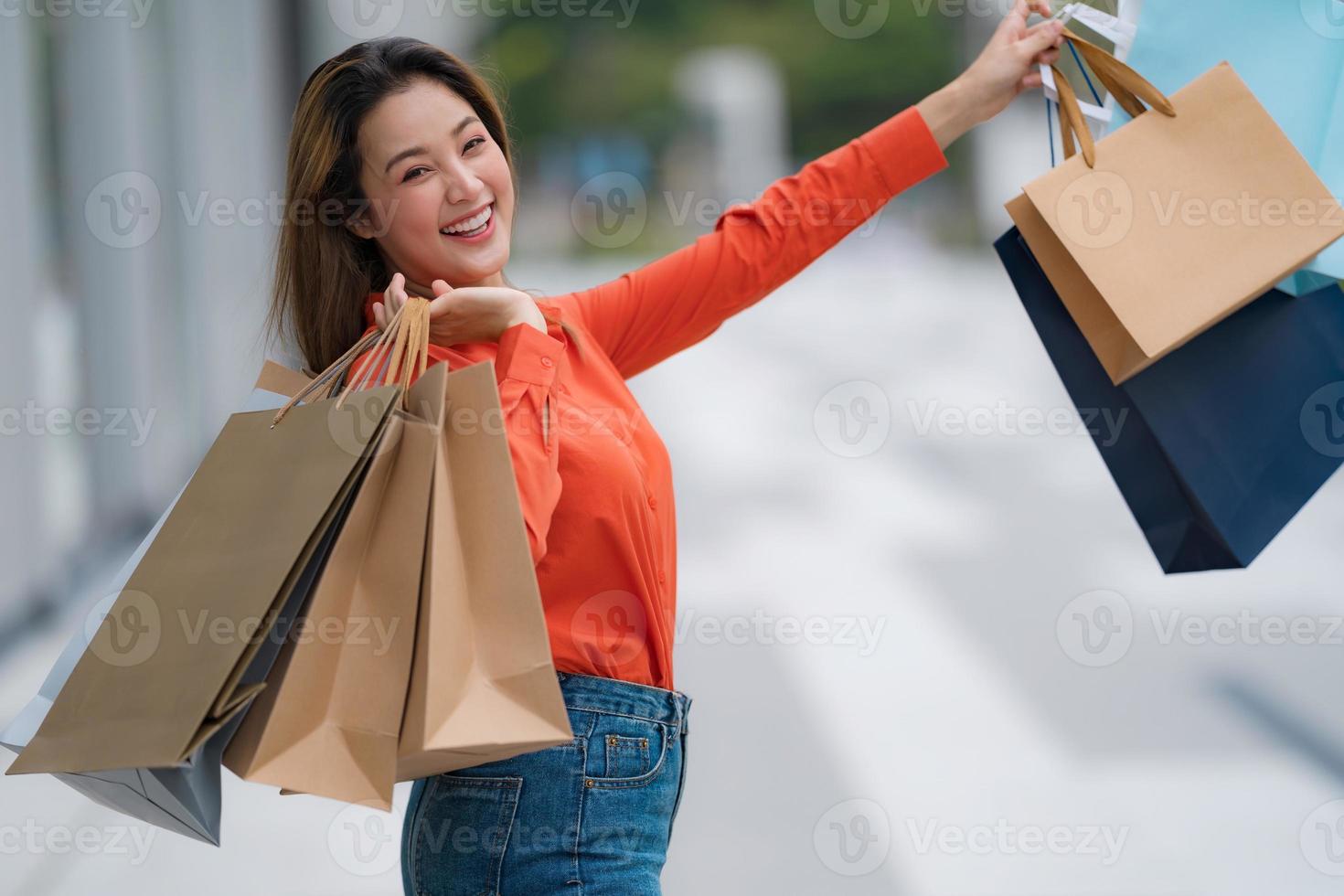 retrato ao ar livre de uma mulher feliz segurando sacolas de compras foto