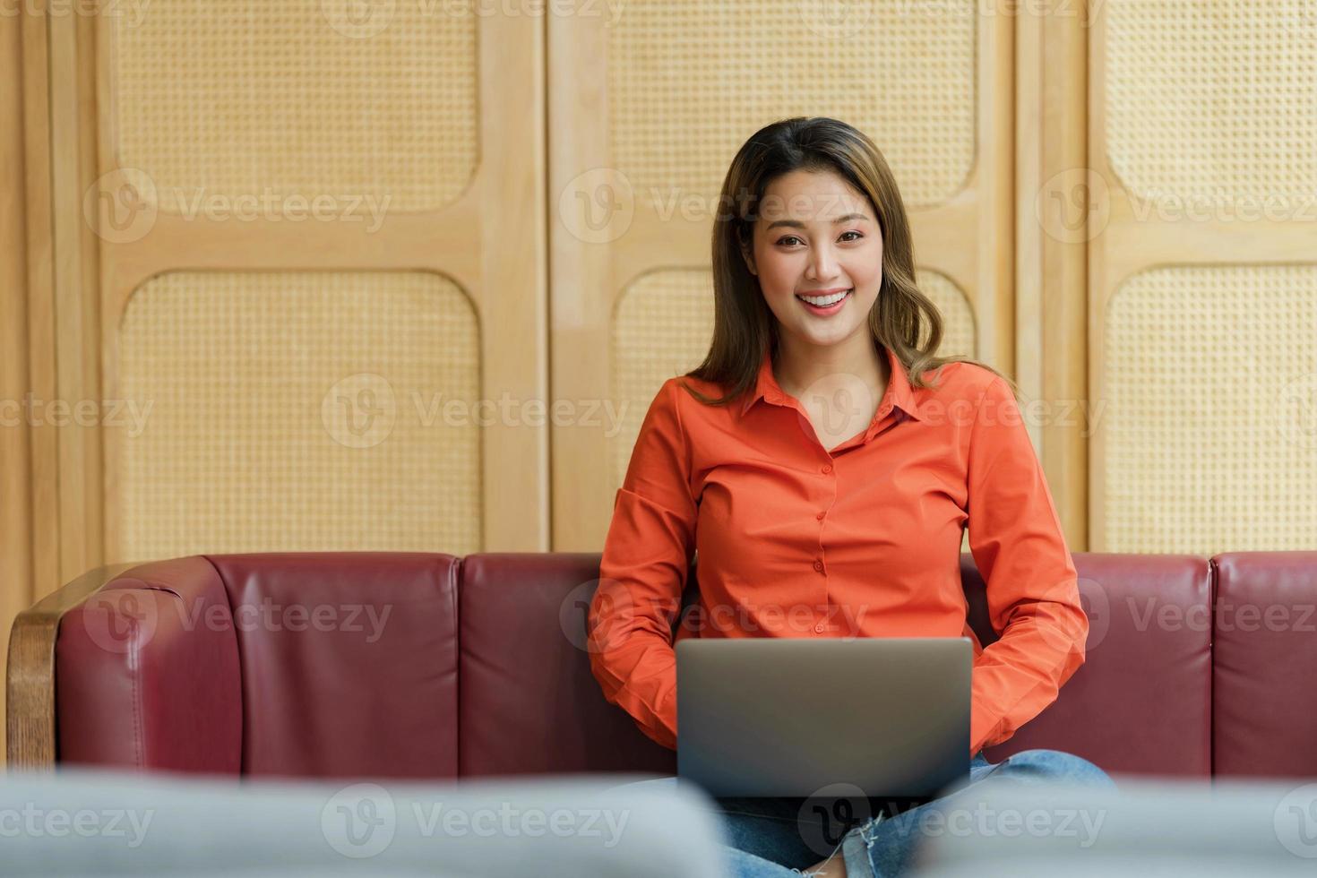 bela jovem usando laptop sentada em uma cafeteria foto