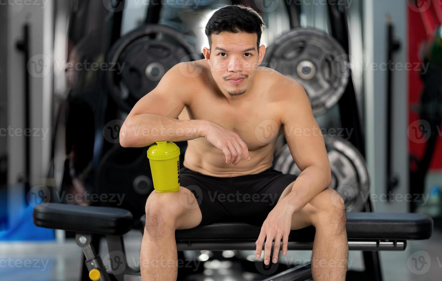homem desportivo a treinar com halteres no ginásio foto