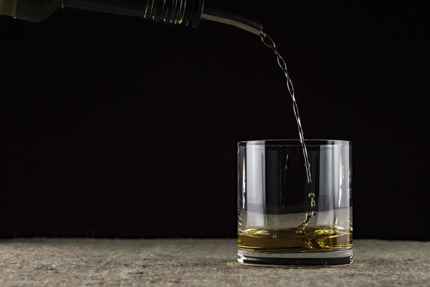 whisky é derramado em um copo foto