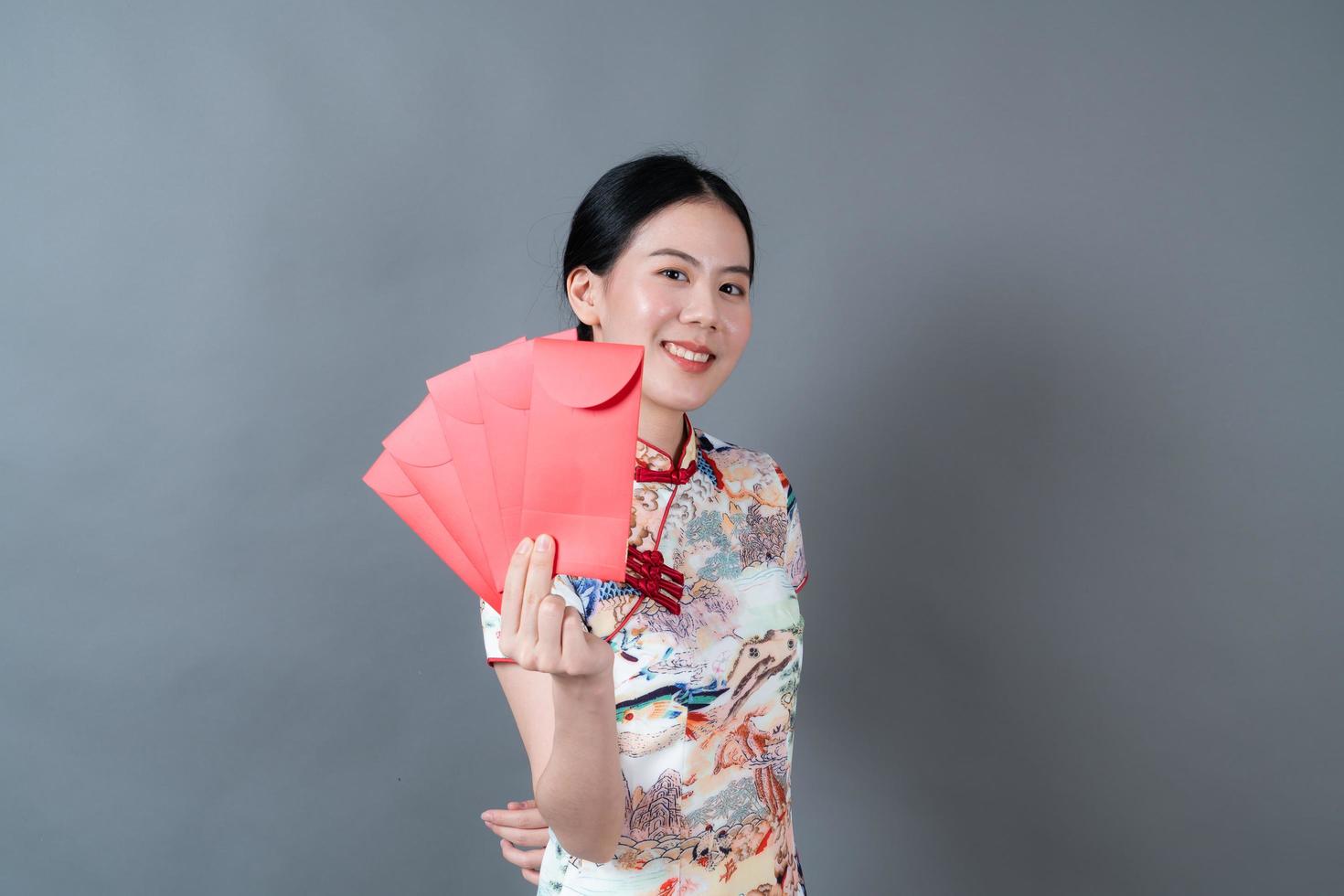 mulher asiática usa vestido tradicional chinês com envelope vermelho ou pacote vermelho foto