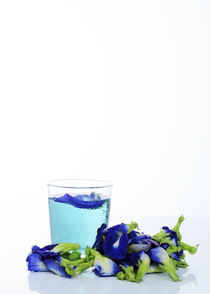 bebida azul com ervilha borboleta em fundo branco foto