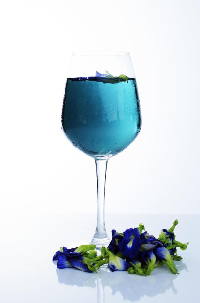 bebida azul com ervilha borboleta em fundo branco foto