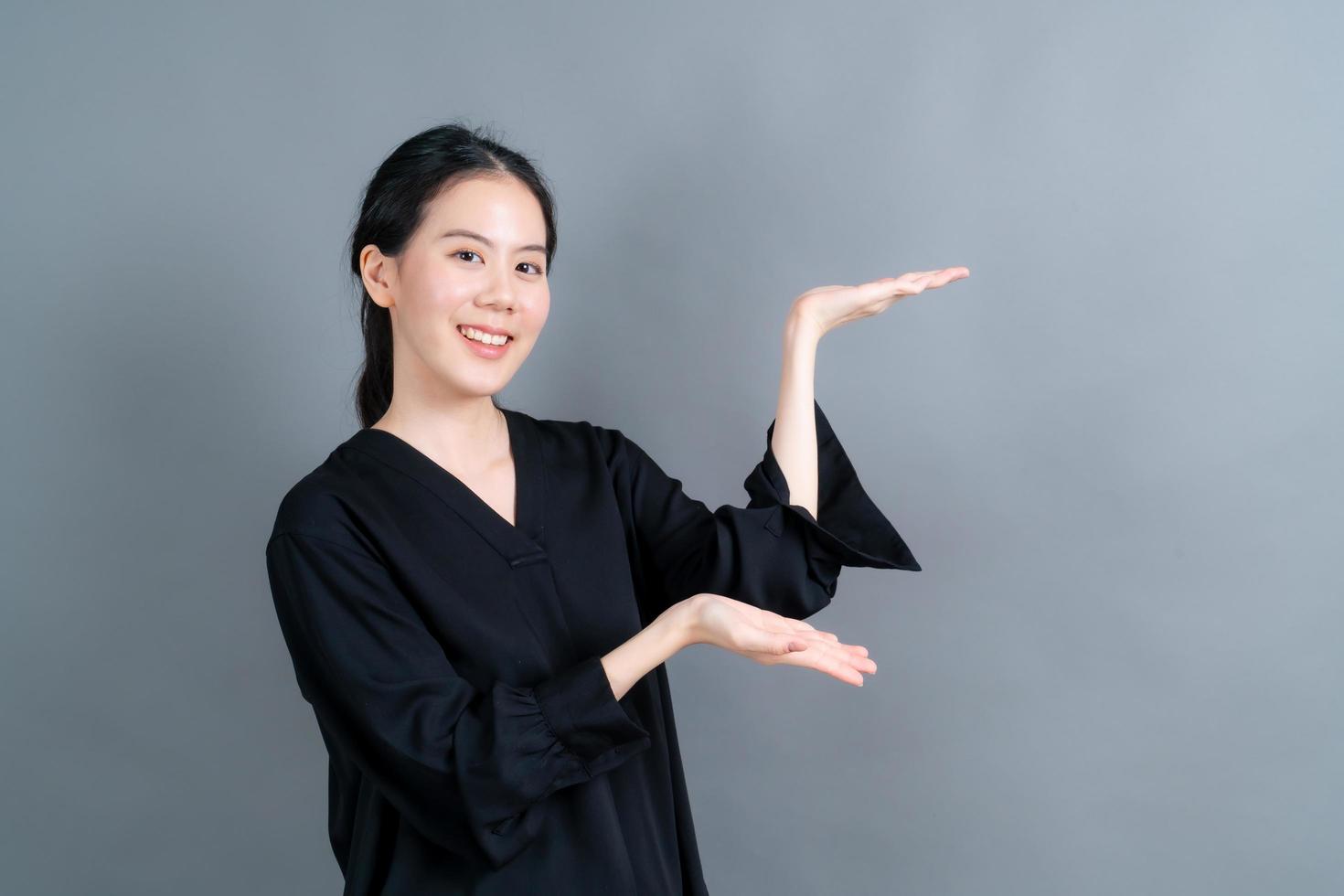 mulher asiática com mão apresentando-se de lado foto