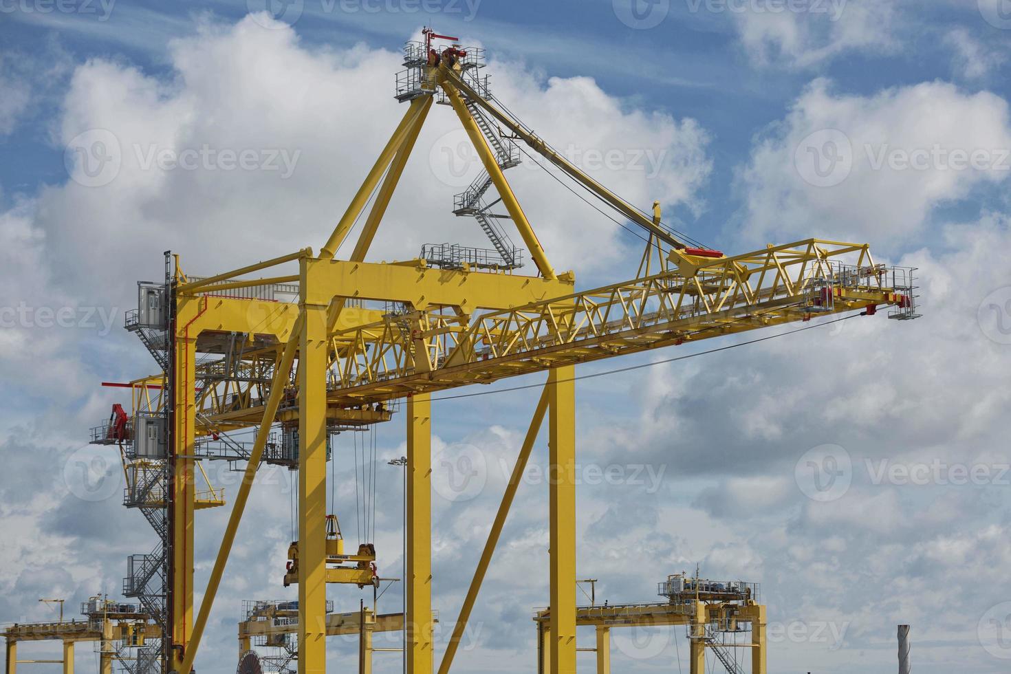 grandes guindastes industriais carregando contêineres no porto de dublin, na irlanda foto