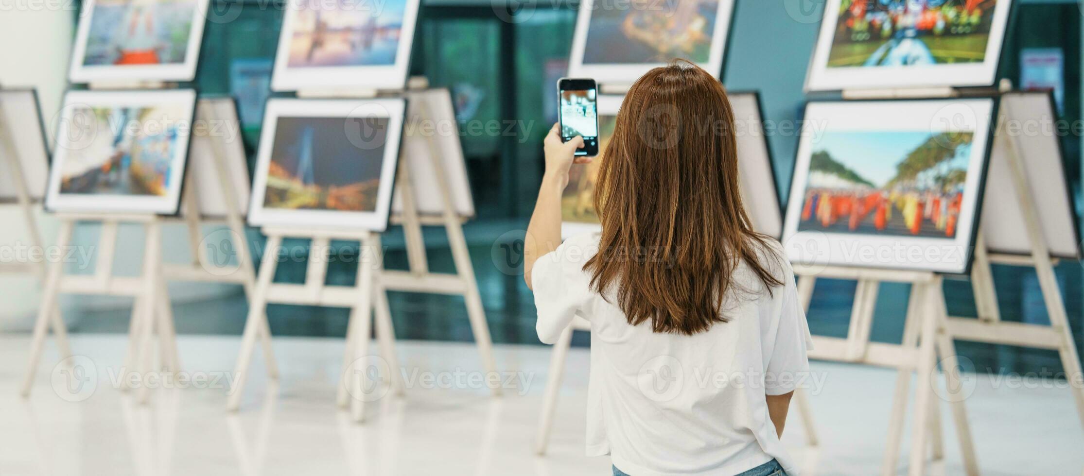 jovem fêmea turista olhando galeria exibição. arte , fotografia e museu conceito foto