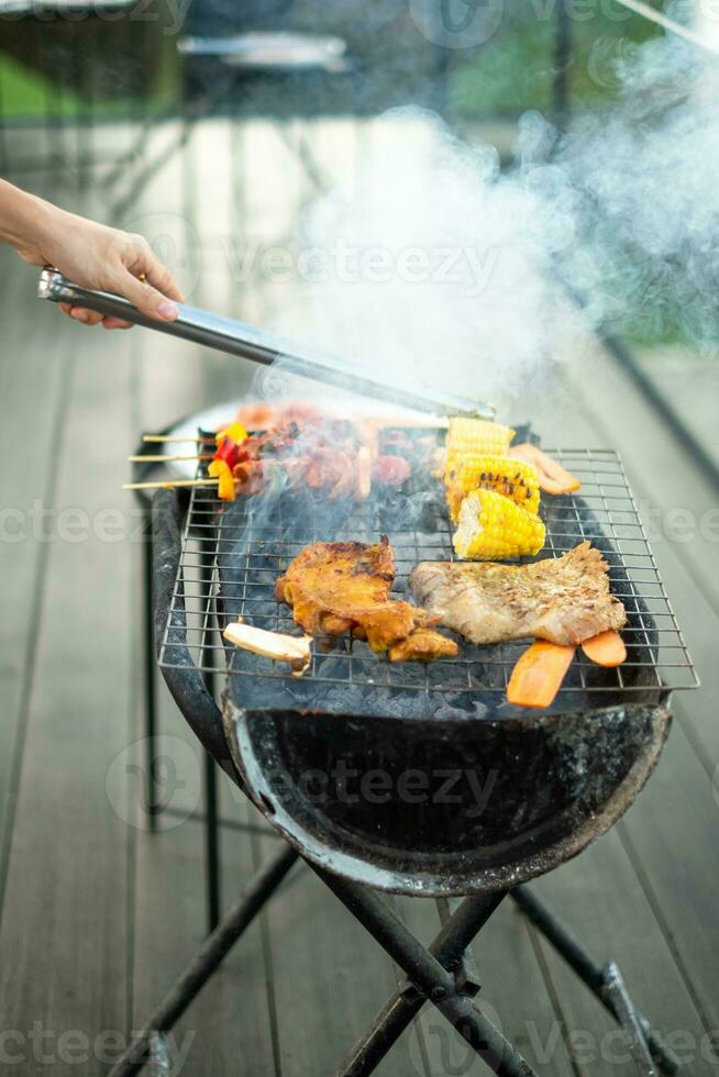 deliciosa carne grelhada com fumaça, churrasco com legumes ao ar livre. churrasco, festa, estilo de vida e conceito de piquenique foto