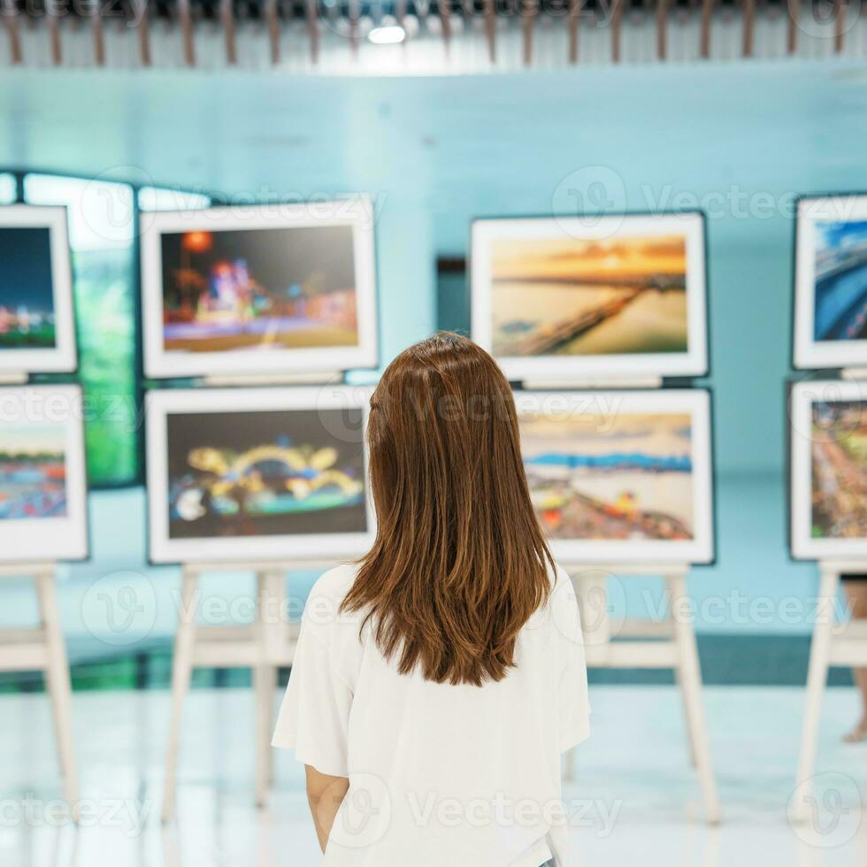 jovem fêmea turista olhando galeria exibição. arte , fotografia e museu conceito foto