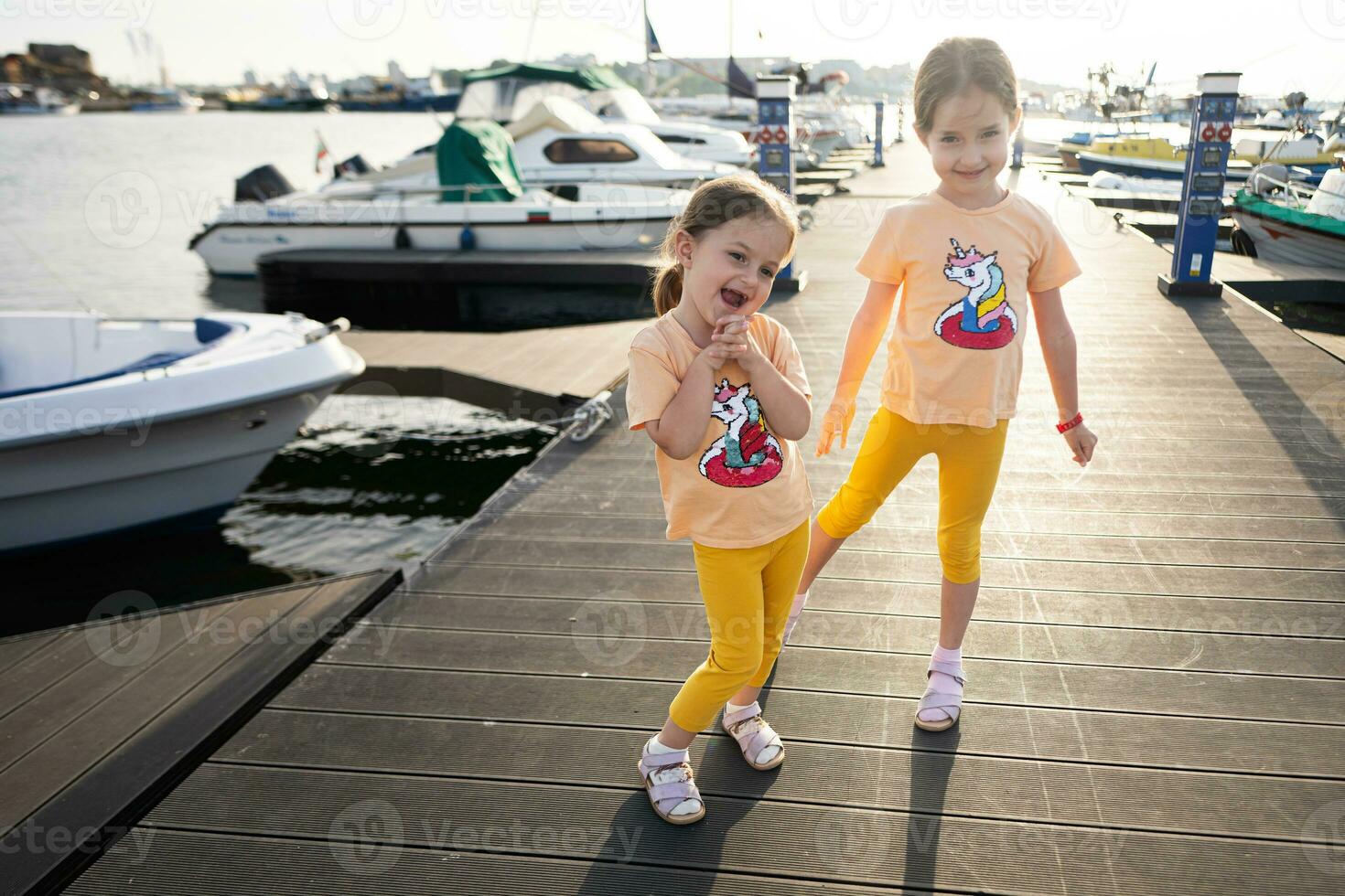 dois pequeno meninas jogando em uma cais dentro a porta do nessebar, Bulgária. foto