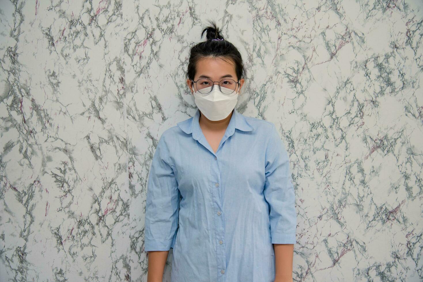 mulher coloca em uma face mascarar em pé com cruzado braços protegendo a partir de vírus durante quarentena isolado em branco plano de fundo, pandemia e social distanciar conceito foto