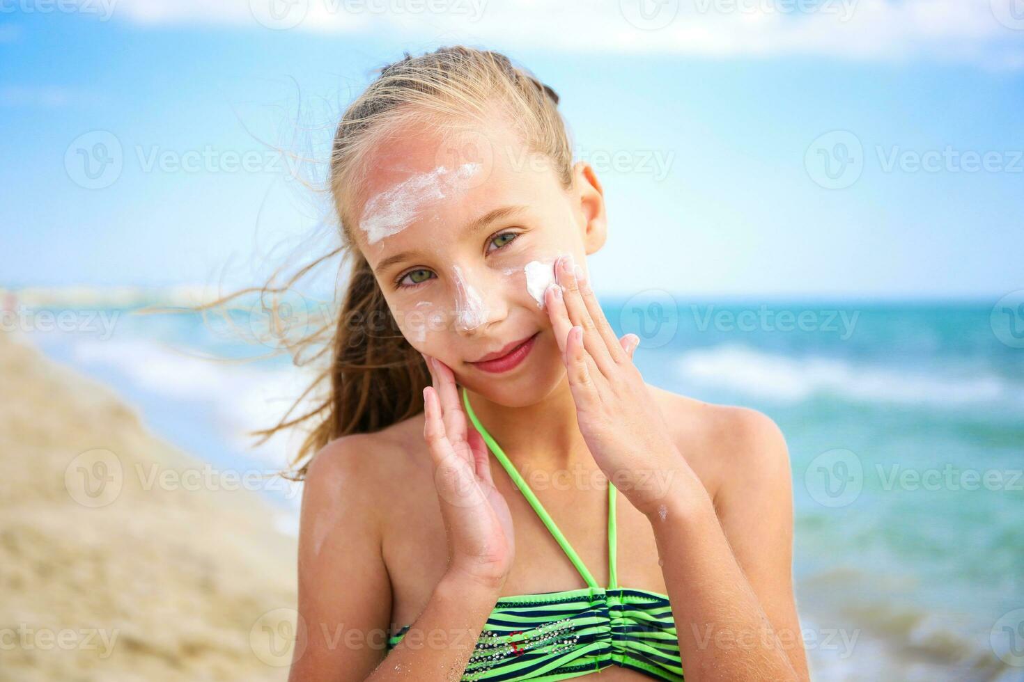 menina aplicando protetora protetor solar em face. foto