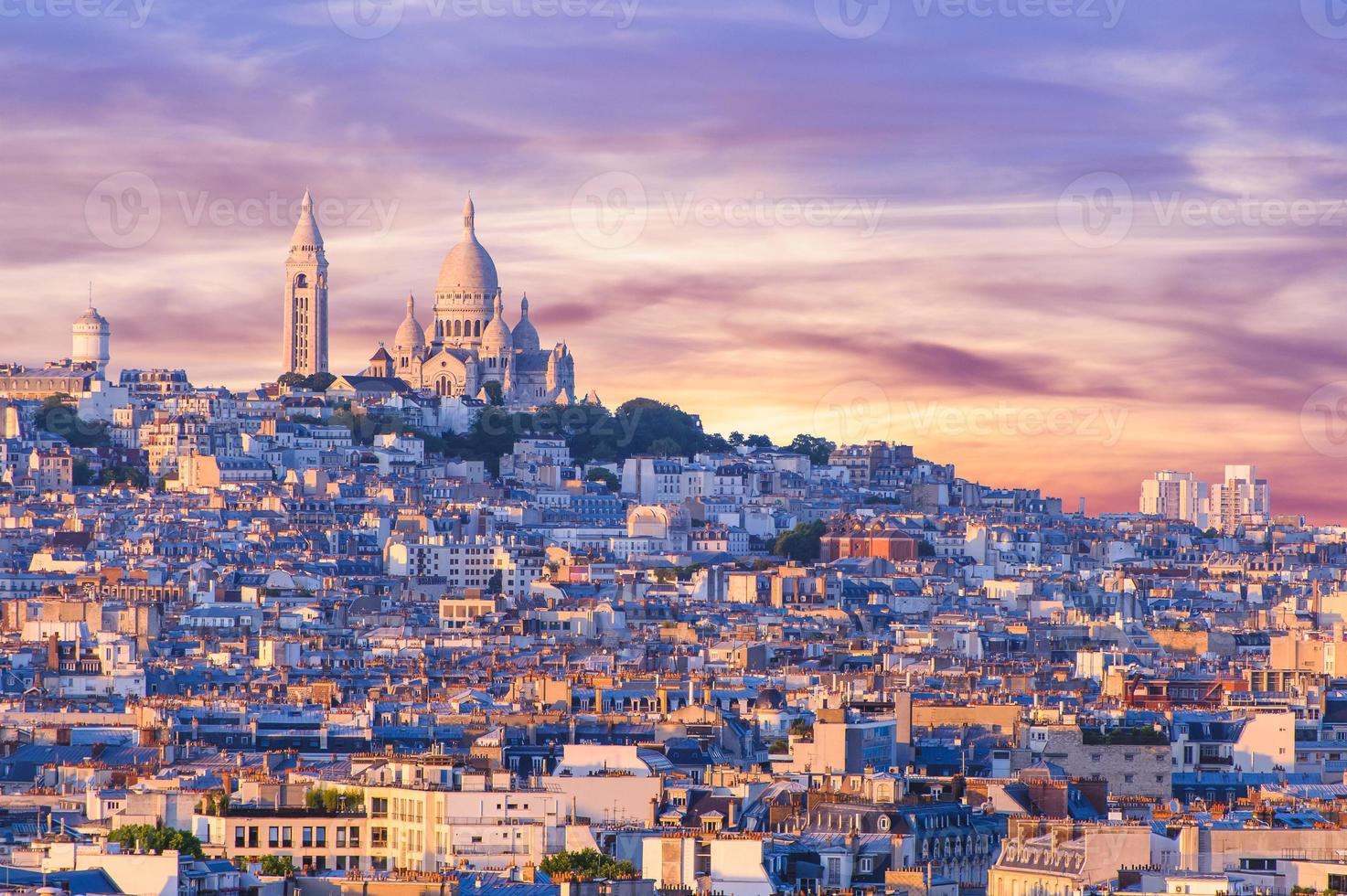 vista da cidade de paris ao pôr do sol com colina de montmartre foto