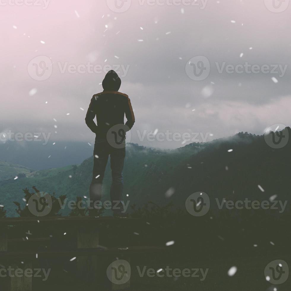 homem caminhando na montanha na temporada de inverno foto