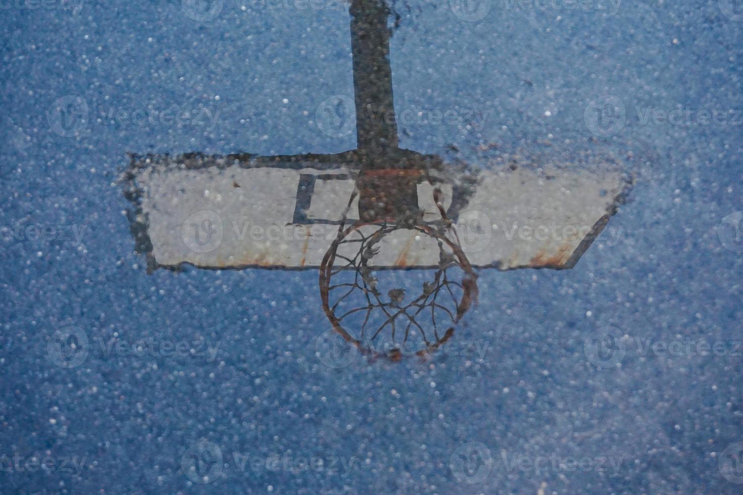 cesta de basquete de rua refletida na poça foto