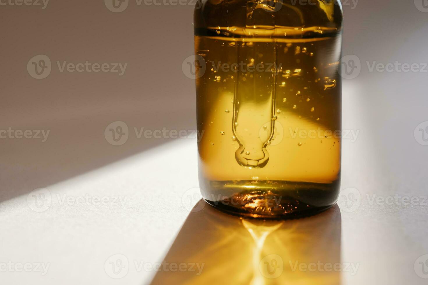 uma Castanho garrafa do sérum contra a bege fundo.. foto