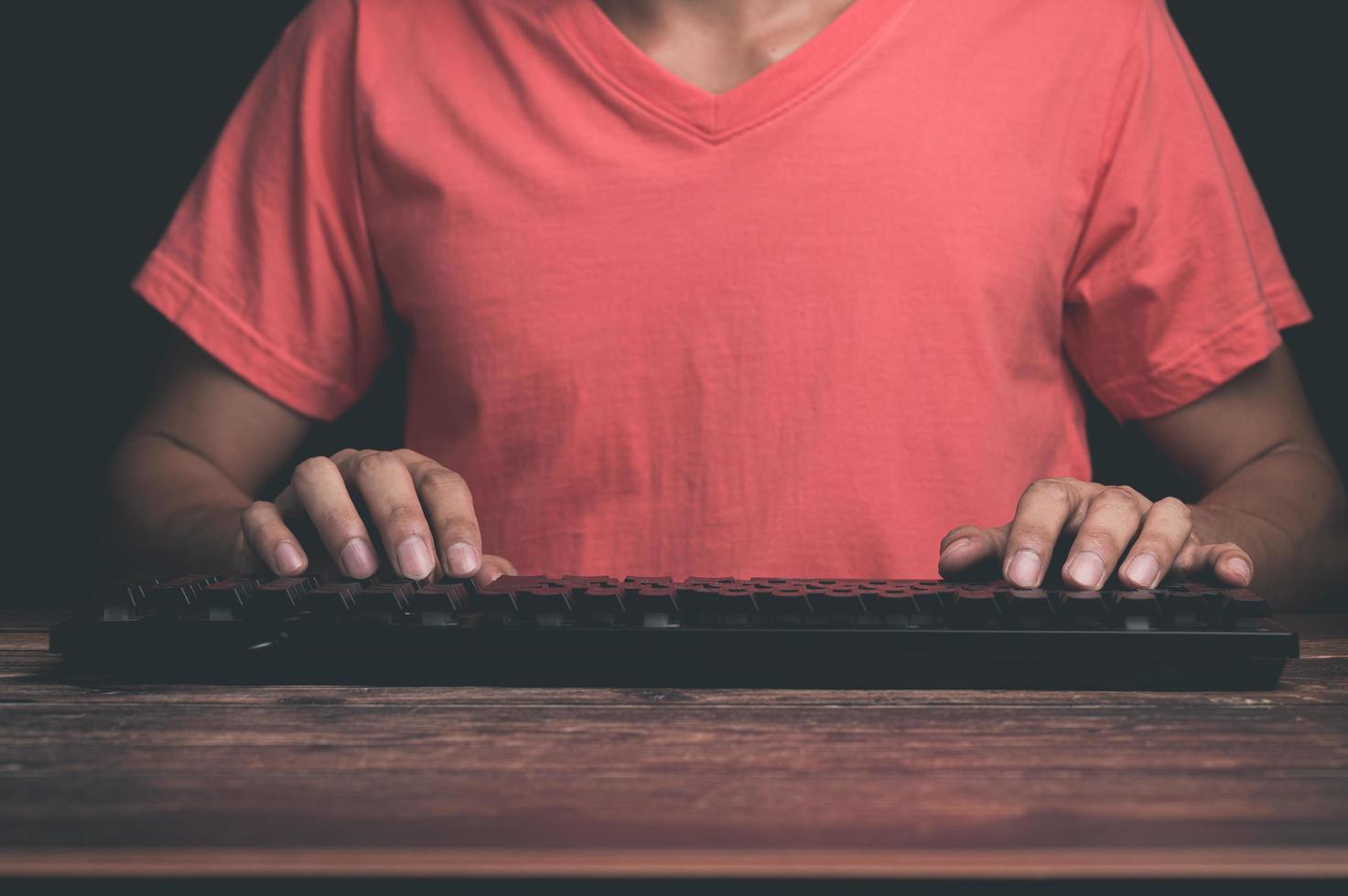 um homem usando um teclado de computador foto