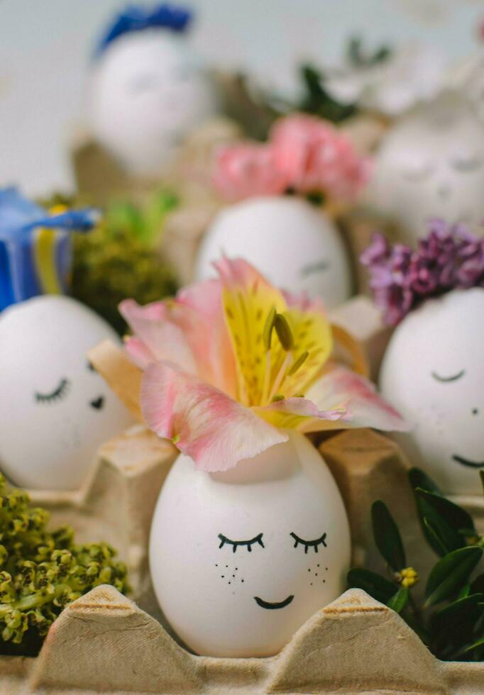 uma ovo com uma face em isto senta dentro uma branco ovo suporte com flores em isto. foto