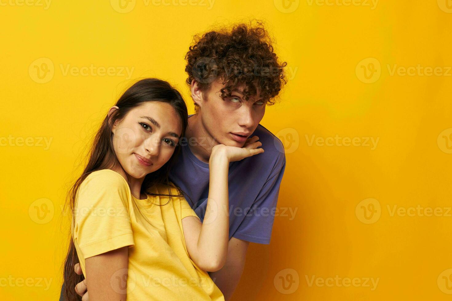 retrato do uma homem e uma mulher dentro colorida Camisetas posando amizade Diversão amarelo fundo inalterado foto