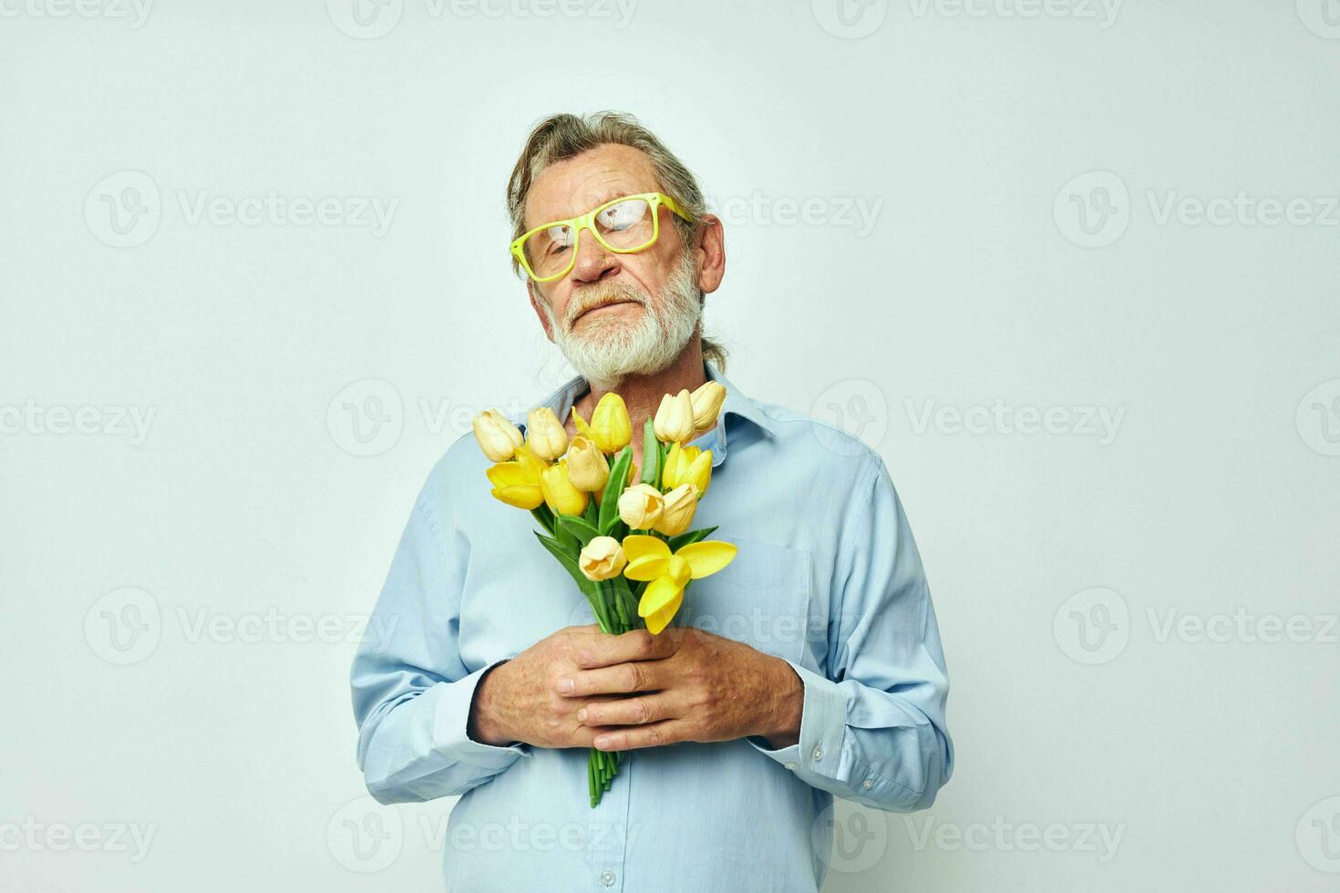 Senior grisalho homem dentro uma azul camisa com uma ramalhete do flores luz fundo foto