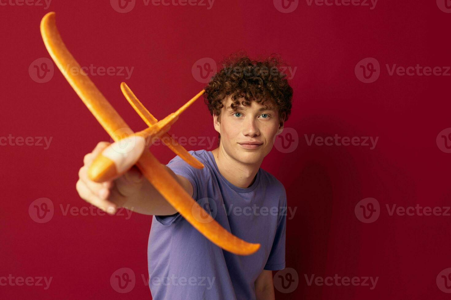 jovem cara com brinquedo avião entretenimento vermelho fundo inalterado foto