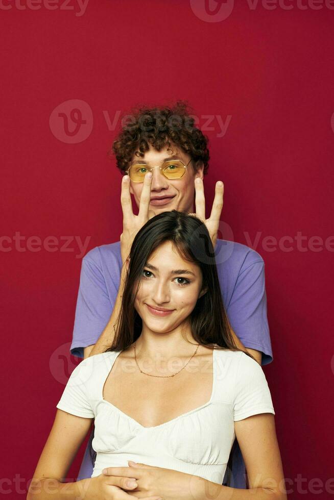 uma jovem casal verão estilo posando moda emoções vermelho fundo foto