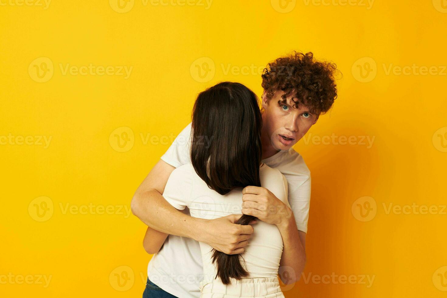 retrato do uma homem e uma mulher ficar de pé abraçando cada de outros dentro branco Camisetas amarelo fundo inalterado foto