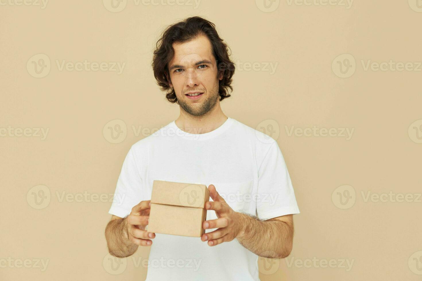 emocional homem com presente pequeno caixa em bege fundo foto