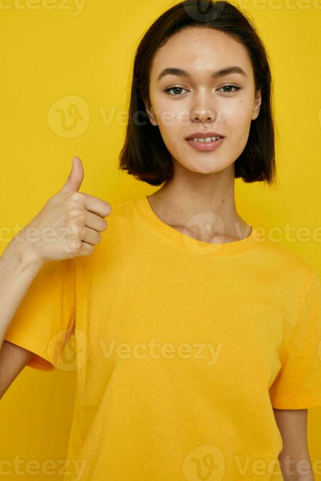 foto bonita menina amarelo camiseta verão estilo mão gesto amarelo fundo