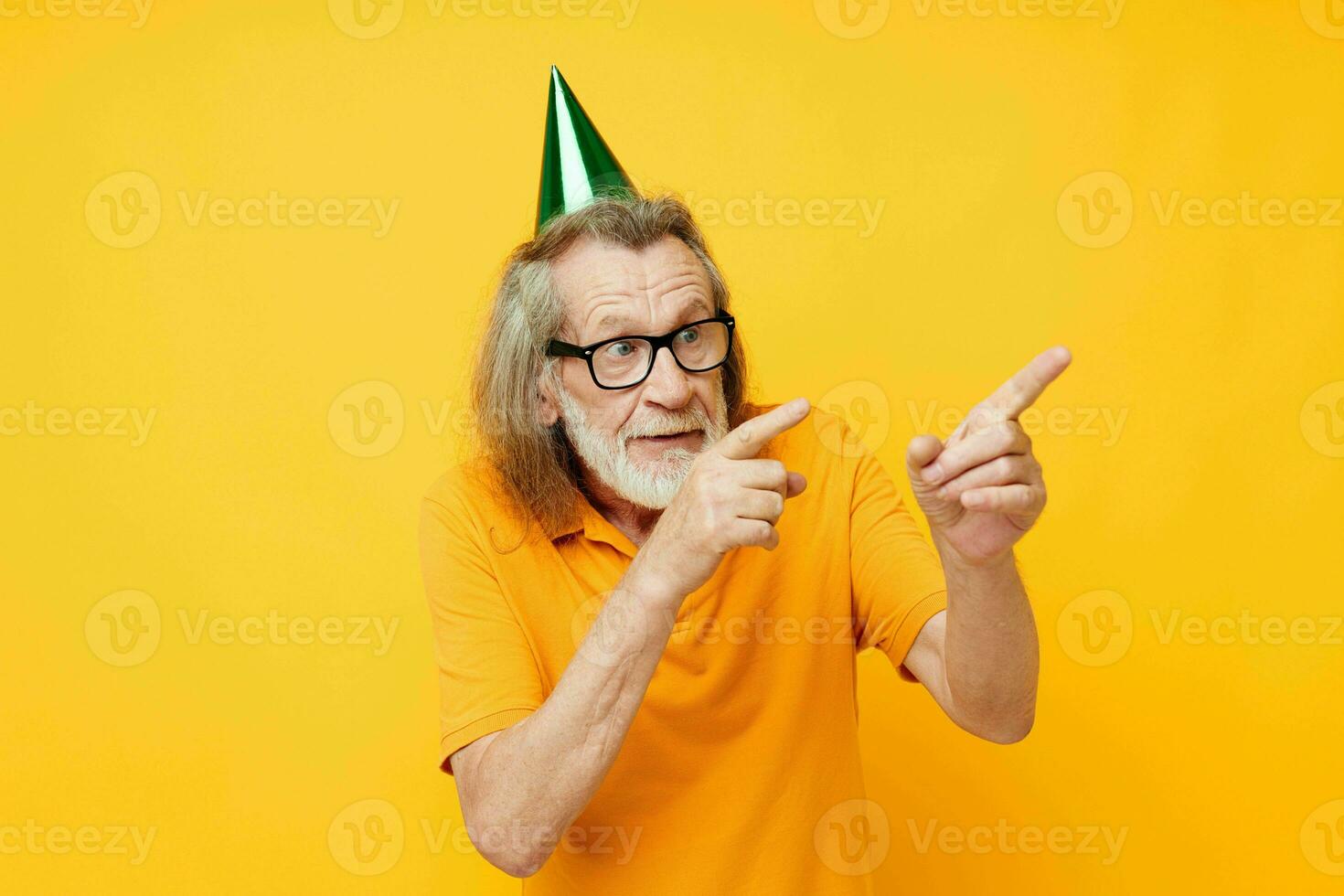 retrato idosos homem dentro uma amarelo camiseta com uma boné em dele cabeça Diversão amarelo fundo foto