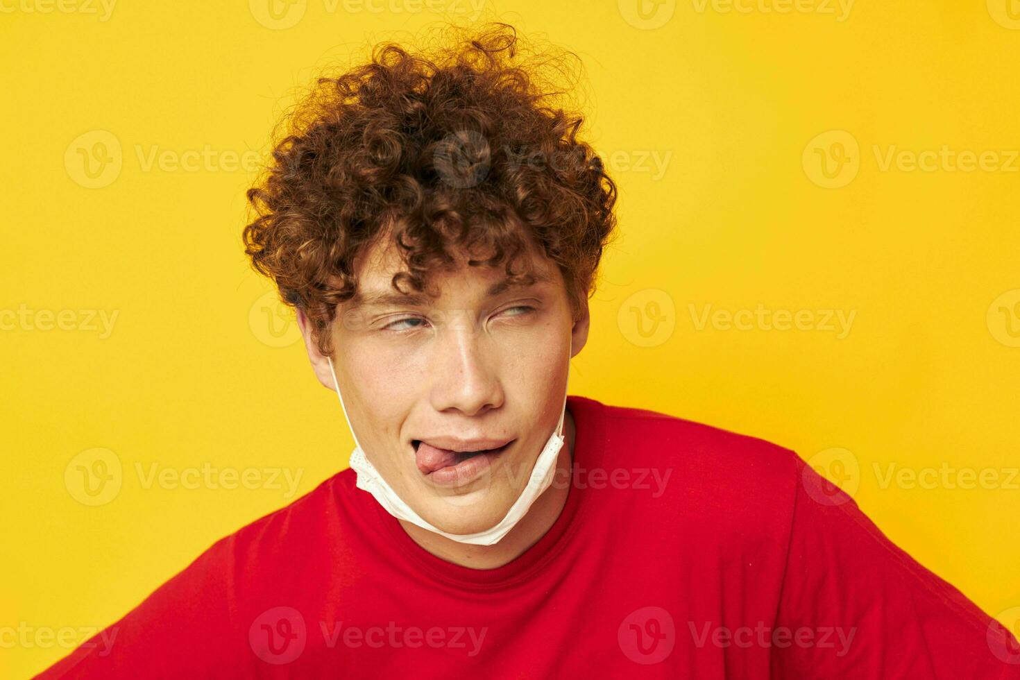 fofa ruivo cara vestindo uma vermelho camiseta médico mascarar em a face posando isolado fundo inalterado foto